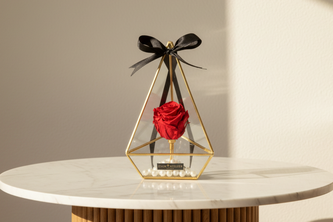 Eternal rose named Opulence by ESOR ATELIER, with vibrant red petals and lush green leaves, displayed in a decorative arrangement.