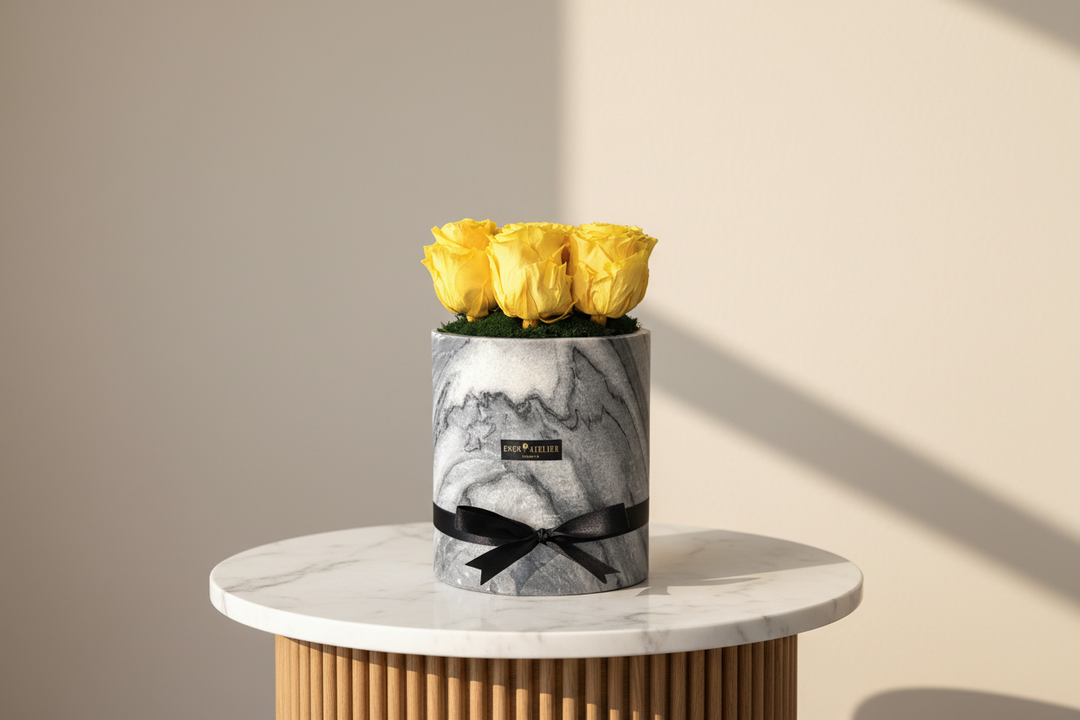 White eternal rose named Noëlle by Esor Atelier displayed against a neutral background, showcasing its delicate petals.