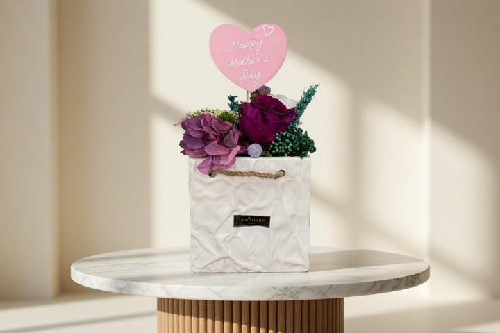 Esor Atelier Maya preserved floral arrangement with vibrant, delicate blooms in a natural display on a neutral background.