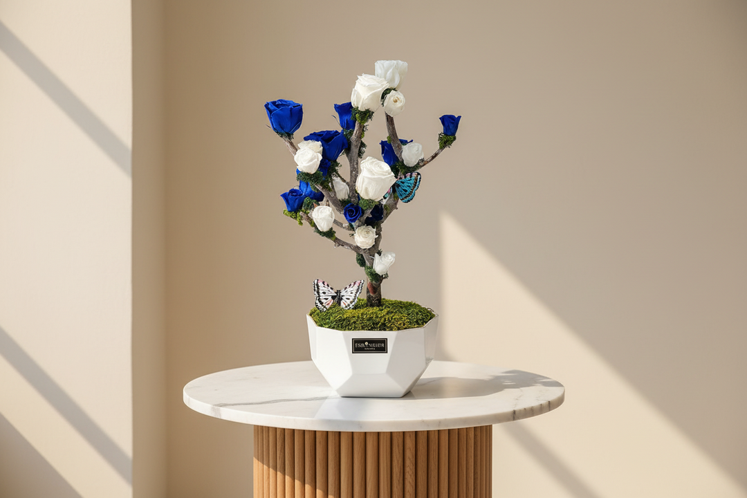 Eternal rose named Lynette from Esor Atelier, displayed in a clear glass dome with delicate petals and lush green leaves.