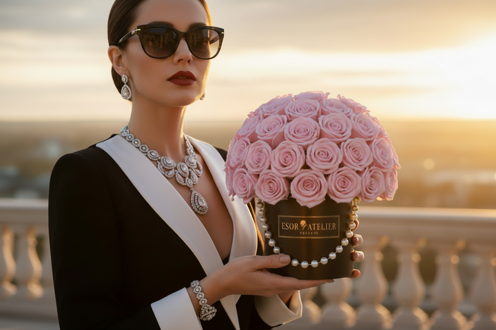 Eternal Rose by Esor Atelier in a delicate glass display, showcasing vibrant petals and elegant green leaves.